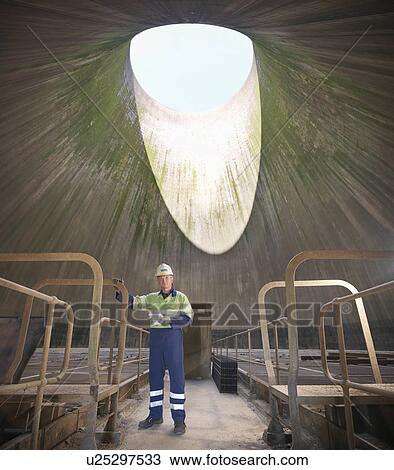 Stock Image - Worker in cooling tower of power station. Fotosearch