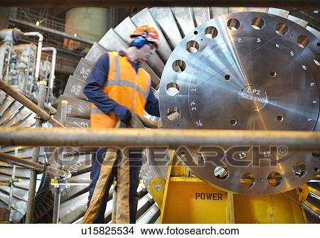 Worker inspects turbine in power station View Large Photo Image Picture - Worker inspects turbine in power station. Fotosearch