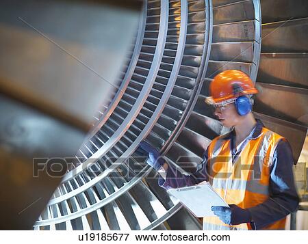Worker inspects turbine in power station View Large Photo Image Stock Photo - Worker inspects turbine in power station. Fotosearch