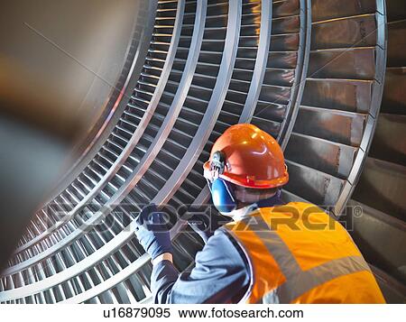 Worker inspects turbine in power station View Large Photo Image Stock Photography - Worker inspects turbine in power station. Fotosearch