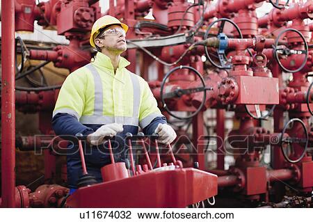 Worker operating machinery on oil rig View Large Photo Image Stock Image - Worker operating machinery on oil rig. Fotosearch