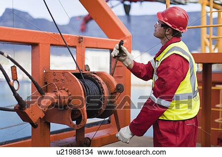 Worker spooling cord on oil rig View Large Photo Image Picture - Worker spooling cord on oil rig. Fotosearch