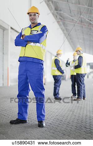 Worker standing in warehouse View Large Photo Image Stock Image - Worker standing in warehouse. Fotosearch