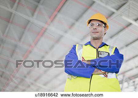 Stock Image - Worker standing in warehouse. Fotosearch
