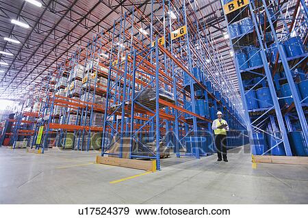 Worker standing in warehouse View Large Photo Image Stock Photo - Worker standing in warehouse. Fotosearch