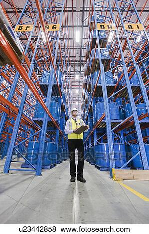 Stock Photo - Worker standing in warehouse. Fotosearch