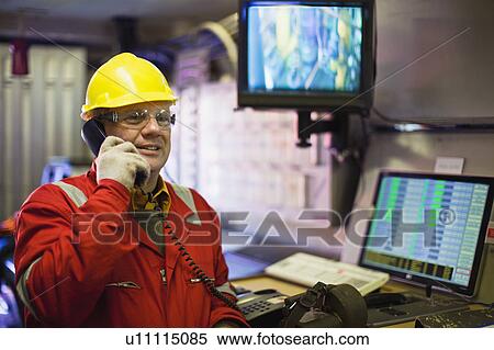 Worker talking on phone in control room View Large Photo Image Stock Photography - Worker talking on phone in control room. Fotosearch