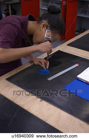 Stock Photo - Worker tracing with compass in factory. Fotosearch