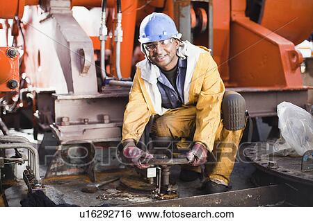 Worker turning wheel on oil rig View Large Photo Image Stock Photograph - Worker turning wheel on oil rig. Fotosearch