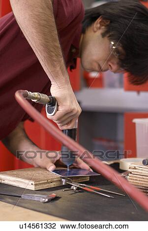 Worker using drill in factory View Large Photo Image Stock Image - Worker using drill in factory. Fotosearch