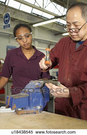 Stock Photography - Worker using hammer in factory. Fotosearch