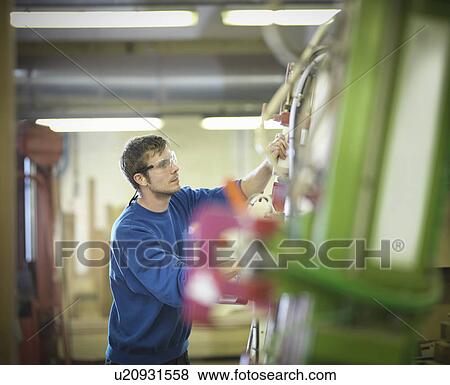 Stock Photo - Worker using machinery in joinery. Fotosearch