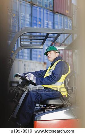 Worker using machinery in shipping yard View Large Photo Image Stock Photo - Worker using machinery in shipping yard. Fotosearch