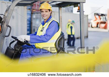 Worker using machinery in shipping yard View Large Photo Image Stock Photograph - Worker using machinery in shipping yard. Fotosearch