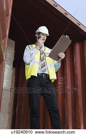 Worker using walkie talkie in container View Large Photo Image Stock Image - Worker using walkie talkie in container. Fotosearch