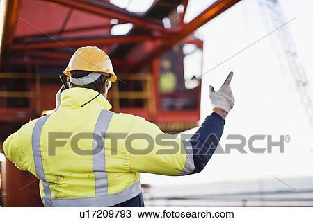 Worker using walkie talkie on oil rig View Large Photo Image Stock Image - Worker using walkie talkie on oil rig. Fotosearch
