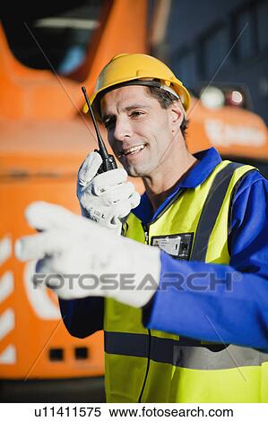 Worker using walkie talkie on site View Large Photo Image Stock Photography - Worker using walkie talkie on site. Fotosearch