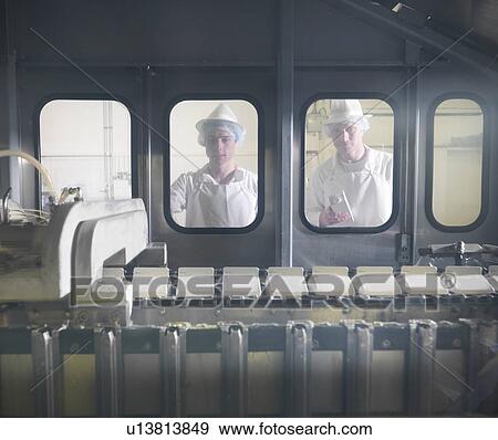 Stock Photo - Worker with goat's milk in dairy. Fotosearch