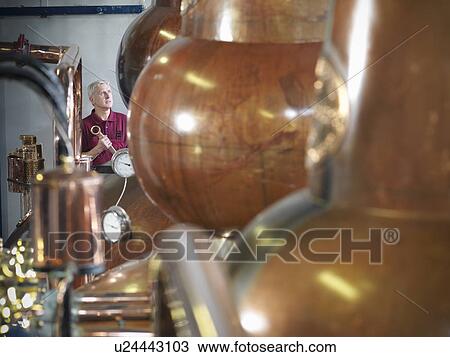 Worker with stills in distillery View Large Photo Image Stock Image - Worker with stills in distillery. Fotosearch
