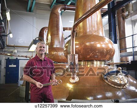 Worker with stills in distillery View Large Photo Image Stock Photo - Worker with stills in distillery. Fotosearch