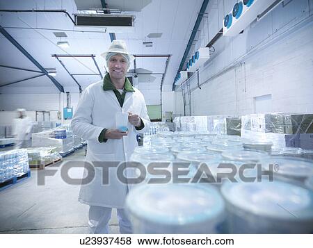 Stock Photo - Worker with yogurt in dairy cold store. Fotosearch