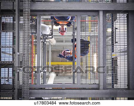 Picture - Workers at biomass storage facility. Fotosearch
