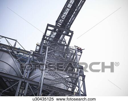Stock Photography - Workers at biomass storage facility. Fotosearch