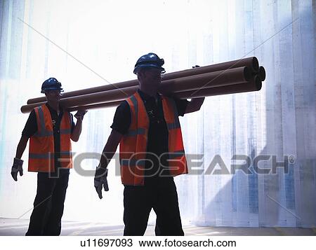 Workers carrying pipes together View Large Photo Image Stock Image - Workers carrying pipes together. Fotosearch