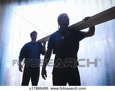 Stock Photography - Workers carrying plank of wood together. Fotosearch