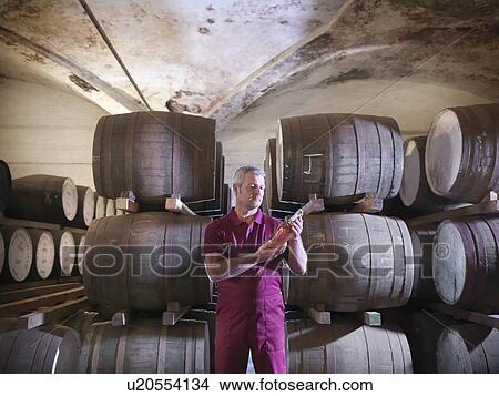 Picture - Workers checking whisky in distillery. Fotosearch