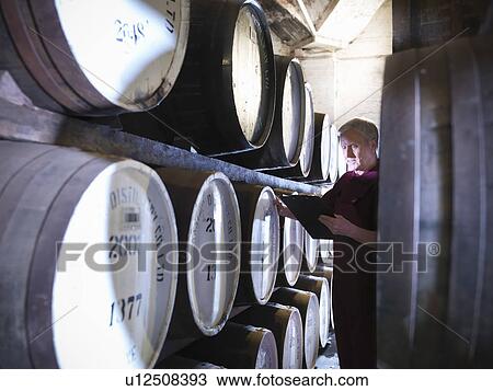 Workers checking whisky in distillery View Large Photo Image Stock Image - Workers checking whisky in distillery. Fotosearch