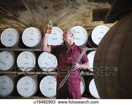 Workers checking whisky in distillery View Large Photo Image Stock Image - Workers checking whisky in distillery. Fotosearch