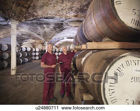 Workers checking whisky in distillery View Large Photo Image Stock Image - Workers checking whisky in distillery. Fotosearch