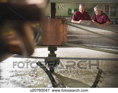 Workers checking whisky in distillery View Large Photo Image Stock Photo - Workers checking whisky in distillery. Fotosearch