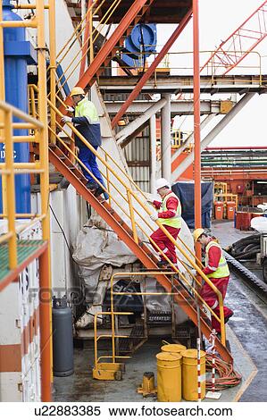 Workers climbing stairs on oil rig View Large Photo Image Stock Photography - Workers climbing stairs on oil rig. Fotosearch