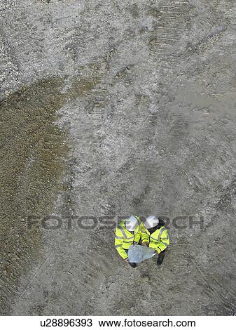 Workers discussing blueprints on site View Large Photo Image Stock Image - Workers discussing blueprints on site. Fotosearch