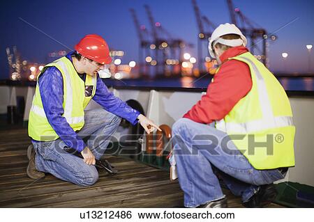 Workers examining machinery on ship View Large Photo Image Stock Photograph - Workers examining machinery on ship. Fotosearch
