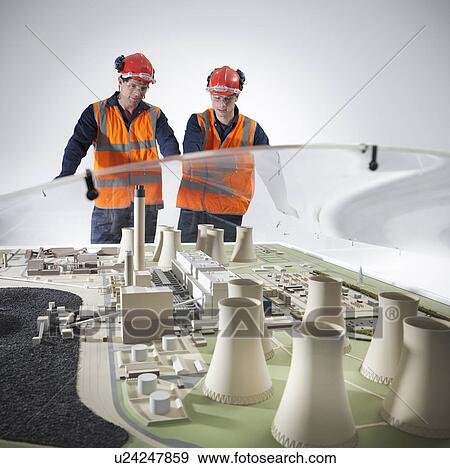 Stock Photo - Workers examining model of power station. Fotosearch