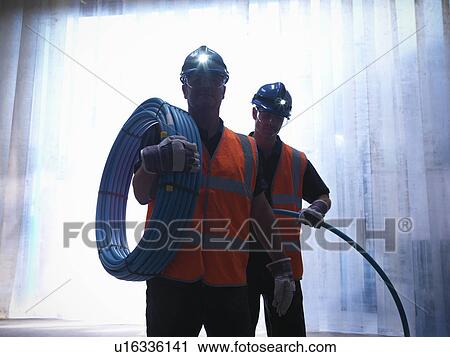 Stock Image - Workers holding water pipes. Fotosearch