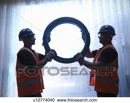 Workers holding water pipes together View Large Photo Image Stock Image - Workers holding water pipes together. Fotosearch