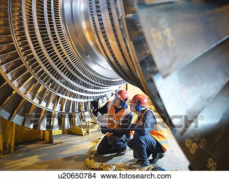 Picture - Workers inspect turbine in power station. Fotosearch