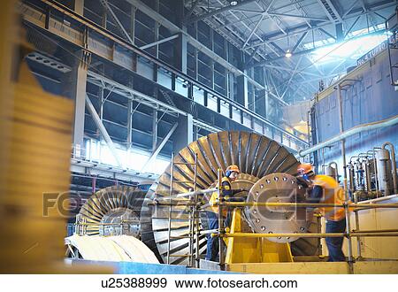 Stock Photo - Workers inspect turbine in power station. Fotosearch