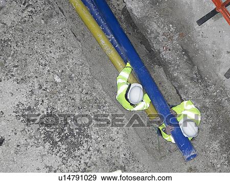 Workers lifting pipes on site View Large Photo Image Stock Photo - Workers lifting pipes on site. Fotosearch