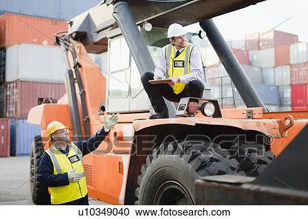 Workers on machinery in shipping yard View Large Photo Image Stock Image - Workers on machinery in shipping yard. Fotosearch