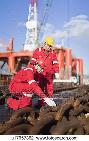 Workers on oil rig examining chains View Large Photo Image Stock Image - Workers on oil rig examining chains. Fotosearch
