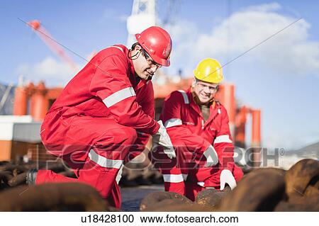 Workers on oil rig examining chains View Large Photo Image Stock Image - Workers on oil rig examining chains. Fotosearch