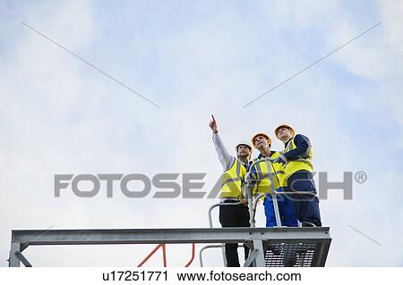Workers overlooking construction site View Large Photo Image Stock Image - Workers overlooking construction site. Fotosearch