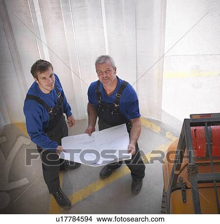 Workers reading blueprints on site View Large Photo Image Picture - Workers reading blueprints on site. Fotosearch