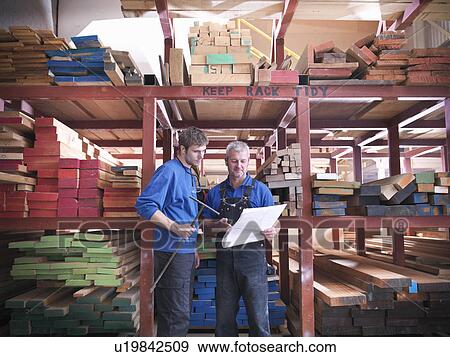 Workers reading together in joinery View Large Photo Image Stock Photo - Workers reading together in joinery. Fotosearch