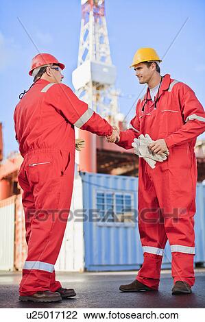 Workers shaking hands on oil rig View Large Photo Image Stock Image - Workers shaking hands on oil rig. Fotosearch